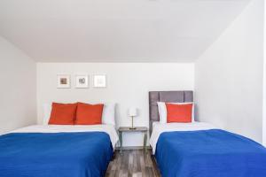 two beds in a room with blue and orange pillows at Gorgeous Flat with Balcony in Besiktas in Istanbul