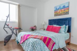 - une chambre avec un lit doté d'une tête de lit bleue et d'oreillers rouges dans l'établissement Penthouse with Private Jacuzzi by GLOBALSTAY, à Lima