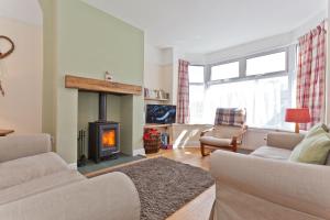 a living room with a fireplace and a couch at Green Croft Coniston in Coniston