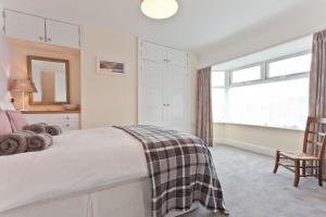 a bedroom with a bed and a chair and a window at Green Croft Coniston in Coniston