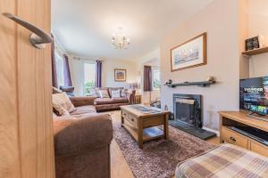 a living room with a couch and a fireplace at Hazel Cottage Coniston in Coniston