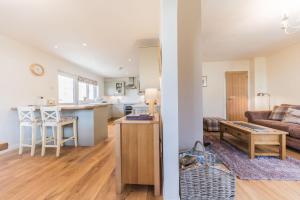 a living room and kitchen with a couch and a table at Hazel Cottage Coniston in Coniston