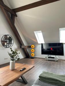 a living room with a table and a tv at Dachterrassenwohnung Katharinenschule in Eisenach