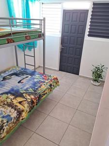 a bedroom with a bunk bed and a door at location Maison Basse-Terre GUADELOUPE in Basse-Terre