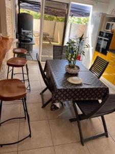 a dining room with a table and chairs and a table at location Maison Basse-Terre GUADELOUPE in Basse-Terre