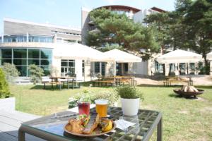 stół z talerzem jedzenia i napojów na nim w obiekcie HAVET Hotel Resort & Spa w Dźwirzynie
