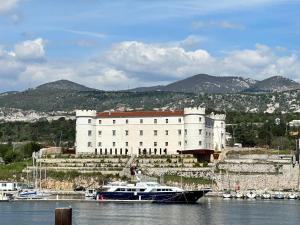 a large white building with a boat in the water at Apartment Nono Anton in Kraljevica