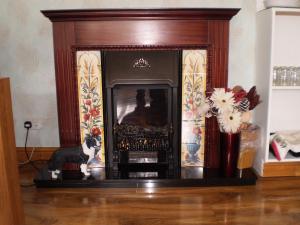 a fireplace with a wooden frame in a living room at Sportsmans Lodge Bed and Breakfast in Amlwch