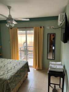 - une chambre avec un lit, un miroir et un balcon dans l'établissement Centro Peru, à Paraná