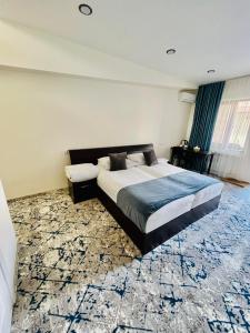 a bedroom with a large bed and a carpet at Fortune Hotel in Yerevan