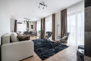 a living room with a white couch and chairs at The Rose Garden Apartments in Budapest