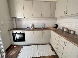 a kitchen with white cabinets and a sink at Santa's Luxury Apartment in Tinos