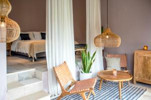 a bedroom with a bed and a table and chairs at The White Villas Ubud in Ubud