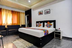 - une chambre avec un grand lit et un canapé dans l'établissement FabExpress Gauri Shree, à Bhopal