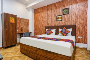 a bedroom with a large bed with a wooden wall at FabExpress Gauri Shree in Bhopal
