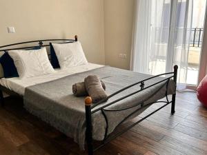 a teddy bear laying on a bed in a bedroom at Santa's Luxury Apartment in Tinos