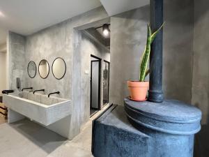 a bathroom with a sink and a potted plant at The Freedom Club Hostel KL in Kuala Lumpur