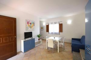 ein Wohnzimmer mit einem Tisch und einem blauen Sofa in der Unterkunft Apartment I Nidi dei Cormorani in Costa Rei