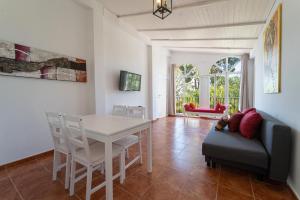 ein Wohnzimmer mit einem weißen Tisch und einer Couch in der Unterkunft CASADELMAR Marbella 23 APARTAMENTOS VACACIONALES in Marbella