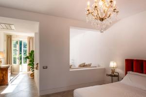 a bedroom with a bed and a chandelier at Agriturismo Villa Toscana in Campiglia Marittima