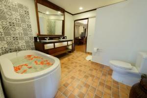 a bathroom with a tub and a toilet and a sink at Villa Deux Rivieres双河别墅酒店 in Luang Prabang