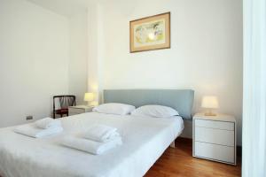 een slaapkamer met een wit bed en 2 witte handdoeken bij Appartamento Trastevere & Pascarella in Rome