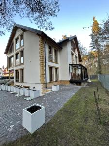 a house with a brick driveway in front of it at Leśna Residence & SPA in Pisz