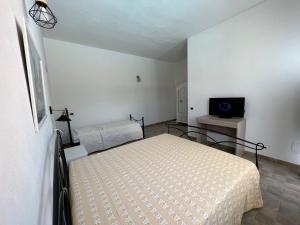 ein Schlafzimmer mit einem Bett und einem TV in der Unterkunft Casa vacanze Mare Fuori in Capoterra