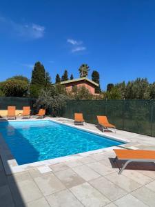 a swimming pool with chairs and a house at Casa vacanze Mare Fuori in Capoterra