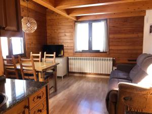 sala de estar con sofá y mesa en Casita de madera a Peu del Riu Incles - Sol y Nieve - Parking incluido en Incles