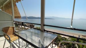 Maresol Lefkada في نِكيانا: طاولة وكراسي على شرفة مطلة على المحيط