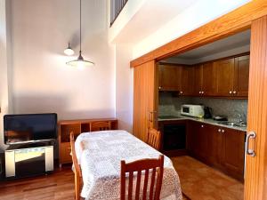 a kitchen with a table and a television in a room at Apartament La Noguera in Rialp