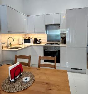 kuchnia z białymi szafkami i drewnianym stołem w obiekcie 1 bedroom apartment in Shepherds Bush, London w Londynie
