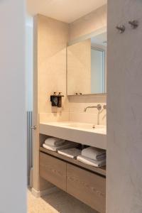 ein Bad mit einem Waschbecken und einem Spiegel in der Unterkunft Hotel Bommelje in Domburg