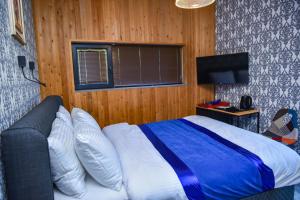 a bedroom with a blue and white bed and a television at 10inn Boutique Hotel in Batumi