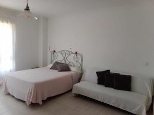 ベナルマデナにあるFantástico estudio en Vela de Marの白いベッドルーム(ベッド1台、ソファ付)