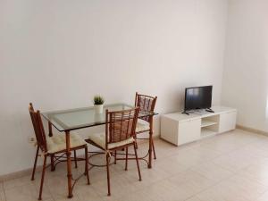 ベナルマデナにあるFantástico estudio en Vela de Marのダイニングルーム(テーブル、椅子、テレビ付)