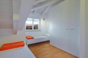 een witte kamer met een bed en een raam bij Residenza ai Ferrari - Appartamento Lilium in Riva del Garda