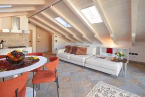 een woonkamer met een witte bank en een tafel bij Residenza ai Ferrari - Appartamento Lilium in Riva del Garda