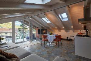een woonkamer met een tafel en een keuken met ramen bij Residenza ai Ferrari - Appartamento Lilium in Riva del Garda