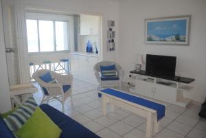 ein Wohnzimmer mit Sofa, Sesseln und Fernseher in der Unterkunft 37 Key Largo in Kingsborough