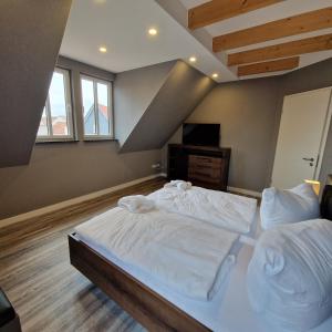 ein Schlafzimmer mit einem großen Bett mit weißer Bettwäsche in der Unterkunft DM Hotes & Apartments - Apartment Rasenweg in Dingelstädt