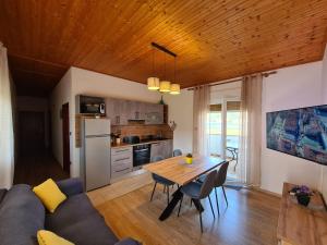 Una sala de estar con una mesa y una cocina. en Apartments Angela Rab, en Supetarska Draga