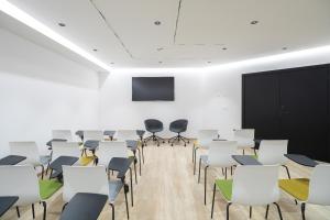 une salle de conférence avec des chaises blanches et un écran dans l'établissement JS Palma Plaza, à Palma de Majorque 37 autres photos