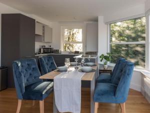 kuchnia ze stołem i niebieskimi krzesłami w obiekcie Pass the Keys Luxury 1 Bed Flat on Windsor Riverside w mieście Windsor
