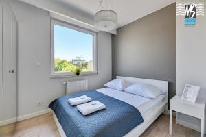 1 dormitorio con 1 cama con 2 toallas en MS Apartments Green Hill I, en Gdynia