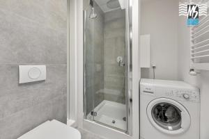 y baño con lavadora y ducha. en MS Apartments Green Hill I, en Gdynia