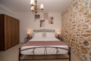 a bedroom with a bed and a stone wall at Pamelas House with Jacuzzi in Kissamos