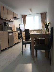 a kitchen with a table and chairs and a kitchen with a window at Apartament u Ani in Wrocław
