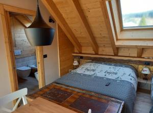 ein Schlafzimmer mit einem Bett in einer Holzhütte in der Unterkunft AL SOGNO in Asiago